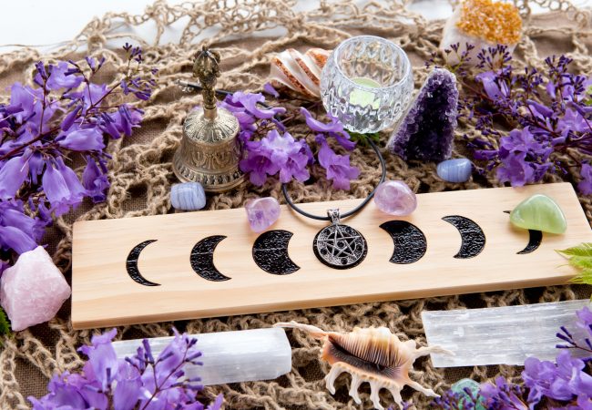 Full Moon Witch Pagan Moon Phases Altar with crystals of selenite and amethyst, with candle, pentacle and purple flowers